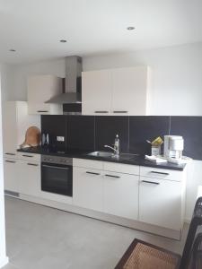 a kitchen with white cabinets and a black counter top at Siebler Übernachtungen am Bauernhof in Wolnzach