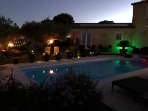 uma piscina em frente a uma casa à noite em Le Claouraous calme em Canet