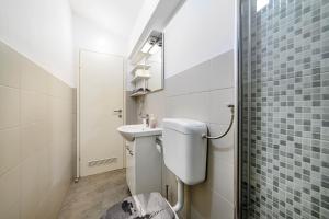 a bathroom with a toilet and a sink at Apartman More in Šibenik +32 photos