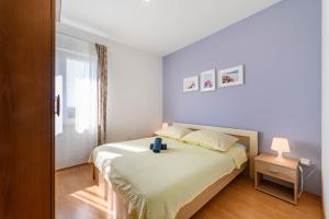 a small bedroom with a bed and a window at Apartman More in Šibenik