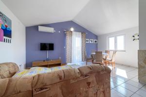 a living room with a couch and a tv at Apartman More in Šibenik