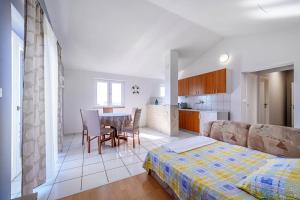 a bedroom with a bed and a table and chairs at Apartman More in Šibenik
