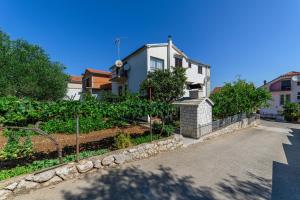 a white house with a fence in front of a driveway at Apartman More in Šibenik