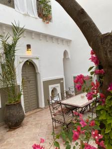 a patio with a table and chairs and flowers at Private house Riad Arlette exclusive in Marrakesh
