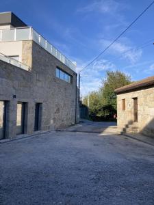 an empty parking lot next to a stone building at Casa do Tavares in Carvalhais