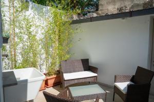 un patio avec des chaises, une baignoire blanche et des plantes dans l'établissement CASA ZEN, à Montesano Salentino