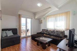 a living room with a couch and a tv at Apartments Janja in Trogir
