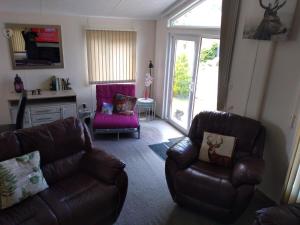 a living room with two chairs and a couch at Squirrel Lodge in Clearwell