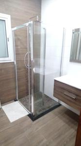 y baño con ducha y puerta de cristal. en S+2 HAUT STANDING à 200m du plage à Dar Allouche / Kélibia / Nabeul en Hanshīr Qaşr Ghallāb