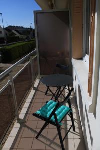 krzesło i telewizor na balkonie w obiekcie L'appartement d'Alexander w Troyes