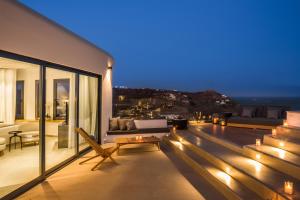 a balcony with a view of the ocean at night at Amyth of Mykonos Super Paradise in Super Paradise Beach