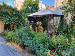 ogród z parasolem i kwiatami w obiekcie Modern and Old LODGE w mieście Sofia