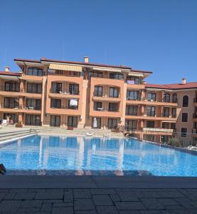 a large building with a large swimming pool in front of it at SUNNY Star Dreams CONDO w PRIME LOCATION, POOL, SEA VIEW in Sveti Vlas
