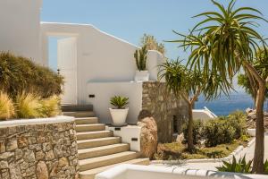 a staircase leading to a white house with palm trees at Amyth of Mykonos Super Paradise in Super Paradise Beach