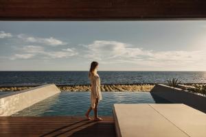 a woman standing on a deck looking out at the ocean at Meraviglia Slow Living in Preveza