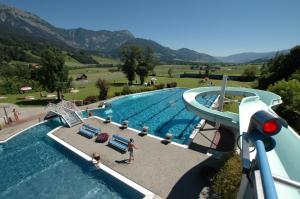 a large swimming pool with a water slide at Hirschberg in Haus im Ennstal