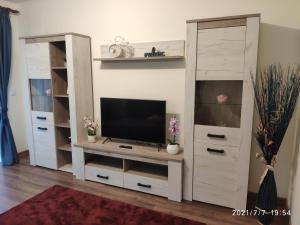 a living room with a tv and a white entertainment center at Cozy House Sinaia in Sinaia