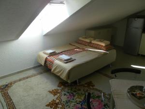 a small bedroom with a bed with a window at Apartments David in Perast