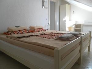 a large bed with a white bed frame in a room at Apartments David in Perast