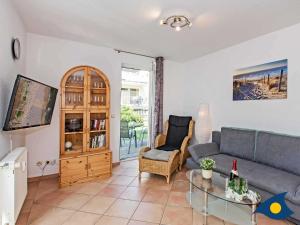 una sala de estar con un sofá y una mesa en Villa Maria Gabriele Whg 02, en Stubbenfelde