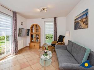 una sala de estar con un sofá y una mesa en Villa Maria Gabriele Whg 02, en Stubbenfelde