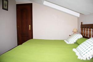 1 dormitorio con 2 camas con sábanas verdes en Casa de Aldea El Valle, en Buelna