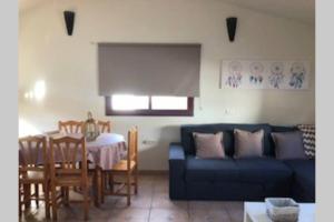 a living room with a blue couch and a table at CASA RURAL MAMÁ in Taibique