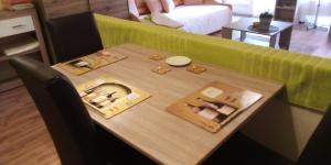 a table in a living room with a green couch at Vadszőlő Vendégház in Cák