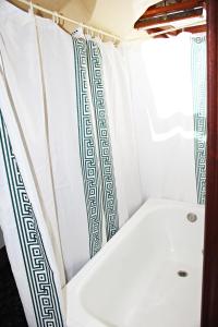 y baño con bañera y cortina de ducha. en Casa de Aldea El Valle, en Buelna