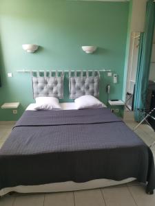 - une chambre avec un grand lit et un mur bleu dans l'établissement Carry Hotel, à Carry-le-Rouet