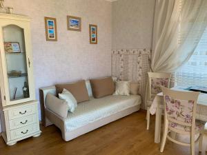 um pequeno quarto com um sofá, uma mesa e um espelho em Apartament Keti em Nessebar