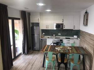 a kitchen with a table and chairs and a kitchen with white cabinets at Casa el Elefante Blanco in Cabárceno