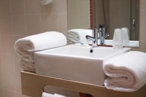 um banheiro com uma pia com toalhas em Hospedaria Robalo no Sabugal