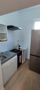 eine Küche mit einer Spüle und einem Kühlschrank in der Unterkunft Soleil Roi - immeuble du 16e siècle en plein coeur de Béziers in Béziers