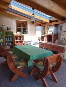una mesa verde y 2 sillas en la cocina en Eszter-lak, en Monostorapáti