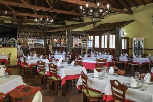 a dining room with white tables and chairs at Hospedaria Robalo in Sabugal