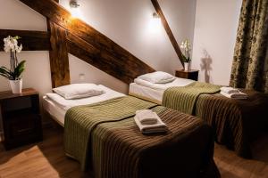 2 łóżka w pokoju hotelowym z ręcznikami w obiekcie Gościniec Kaszubski w Kartuzach