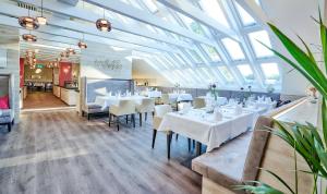 a dining room with white tables and chairs at Vitalhotel Bad Birnbach in Bad Birnbach