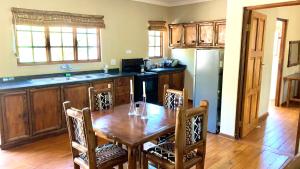 a kitchen with a wooden table and a refrigerator at Hope Haven Cottage in Nelspruit +31 photos
