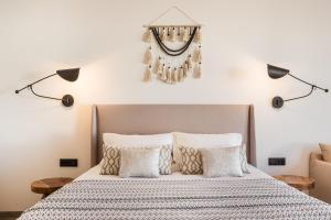 a bedroom with a bed with pillows and a chandelier at Amyth of Mykonos Super Paradise in Super Paradise Beach