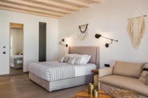 a bedroom with a bed and a couch at Amyth of Mykonos Super Paradise in Super Paradise Beach