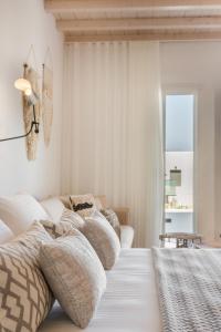 a white room with a bed with pillows on it at Amyth of Mykonos Super Paradise in Super Paradise Beach