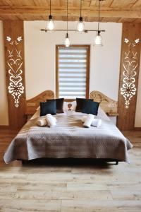 a bedroom with a large bed with two pillows at Willa Strążyski Potok in Zakopane