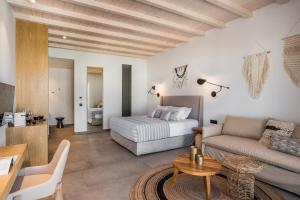 a hotel room with a bed and a couch at Amyth of Mykonos Super Paradise in Super Paradise Beach