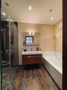 a bathroom with a sink and a tub and a shower at Mona Apartment in Going