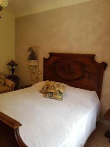 1 dormitorio con 1 cama con cabecero de madera en Nel giardino di Dafne, en Stresa