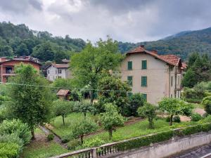 a large building in a town with trees and a river at Locanda del Brinsc in Brinzio