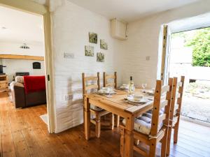 a dining room with a wooden table and chairs at Spring Cottage in Llandysul