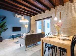 a dining room and living room with a table and chairs at Suites Triana Sevilla Apartments in Seville