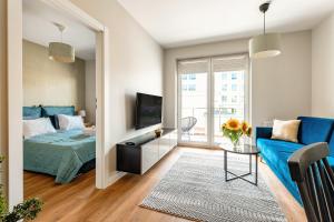 a bedroom with a blue bed and a blue couch at Aparthotel Plac Litewski Premium in Lublin